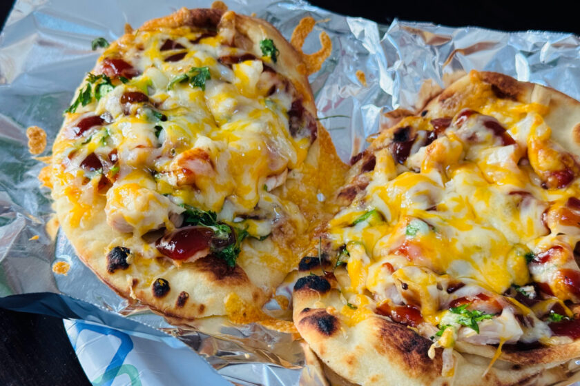 Mini BBQ chicken naan pizzas on tin foil.