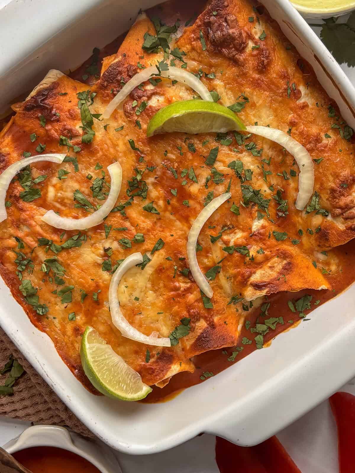 black bean enchiladas in white casserole dish.