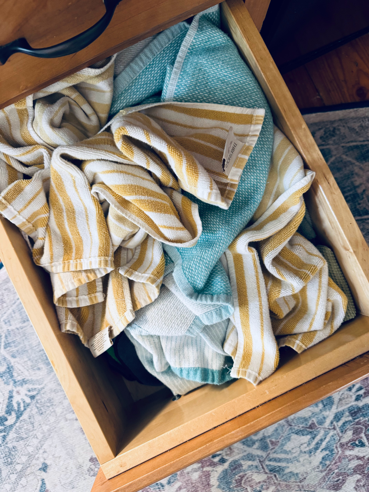 drawer dull of dish towels and rags to be decluttered.