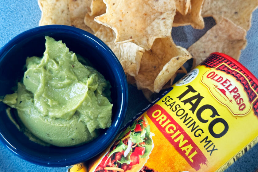 guacamole in small blue ramekin with Old El Paso Taco Seasoning and Scoops tortilla chips.