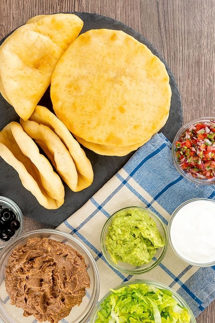 chalupas on platter with copycat taco bell chalupa supreme ingredients in small bowls.