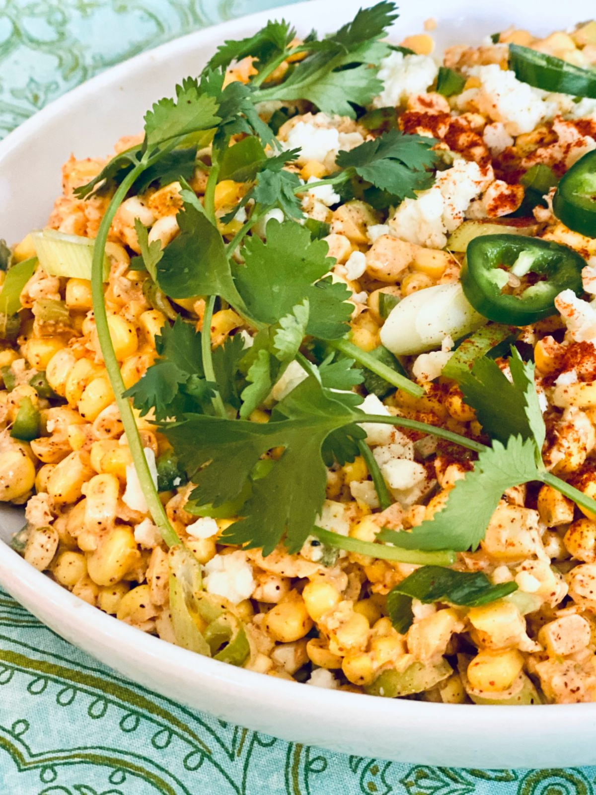 mexican corn salad topped with cilantro and jalapenos.