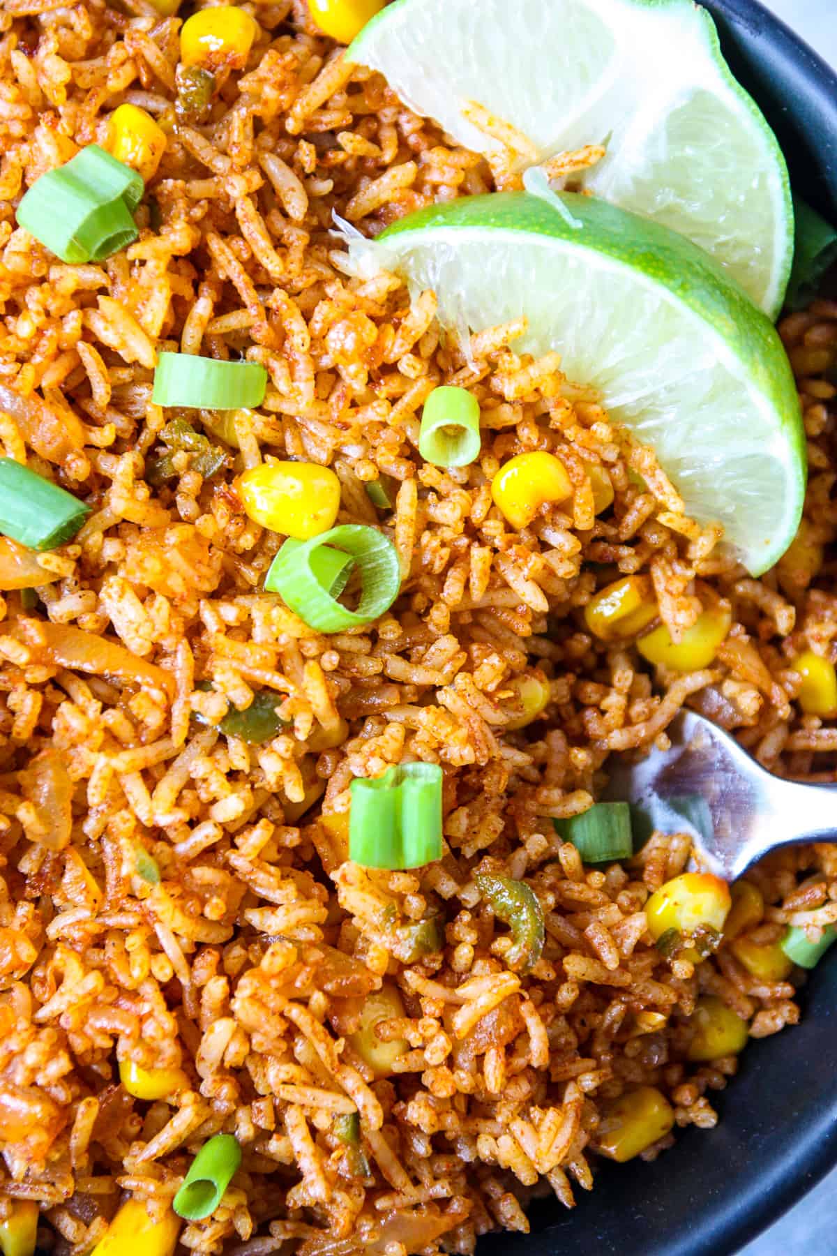 Mexican fried rice in skillet with lime.