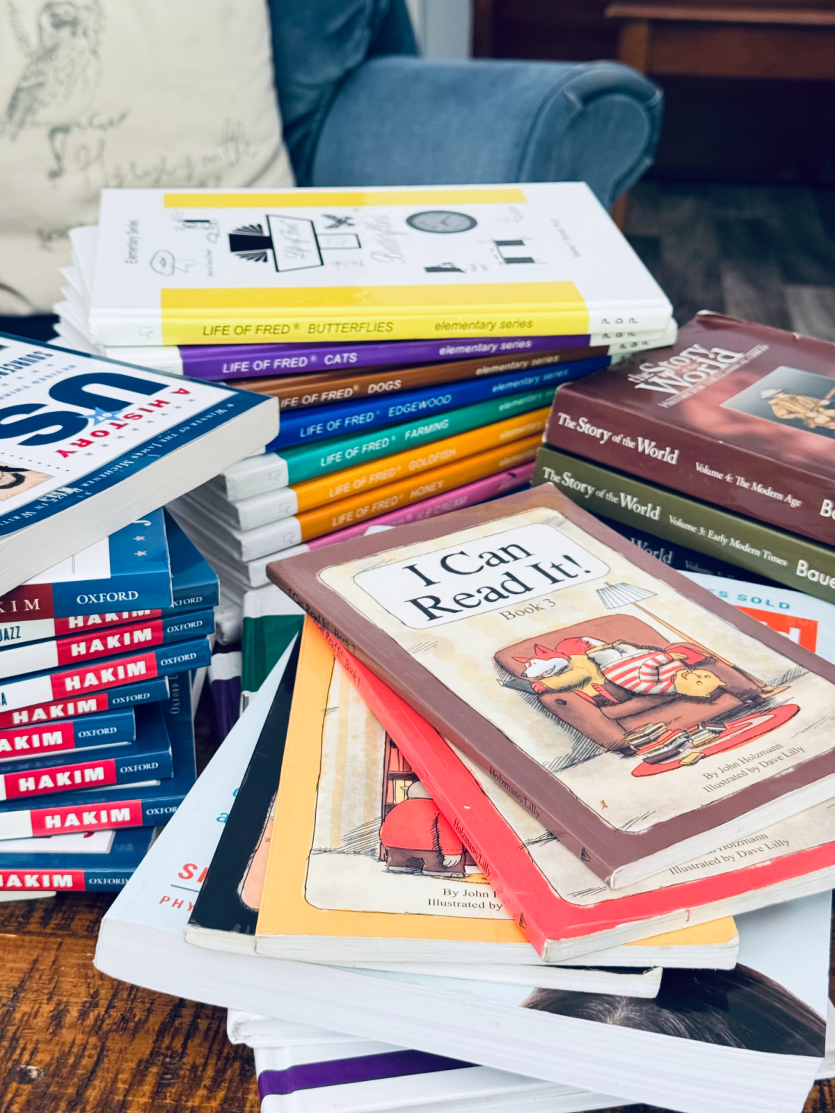 piles of homeschool books on coffee table.