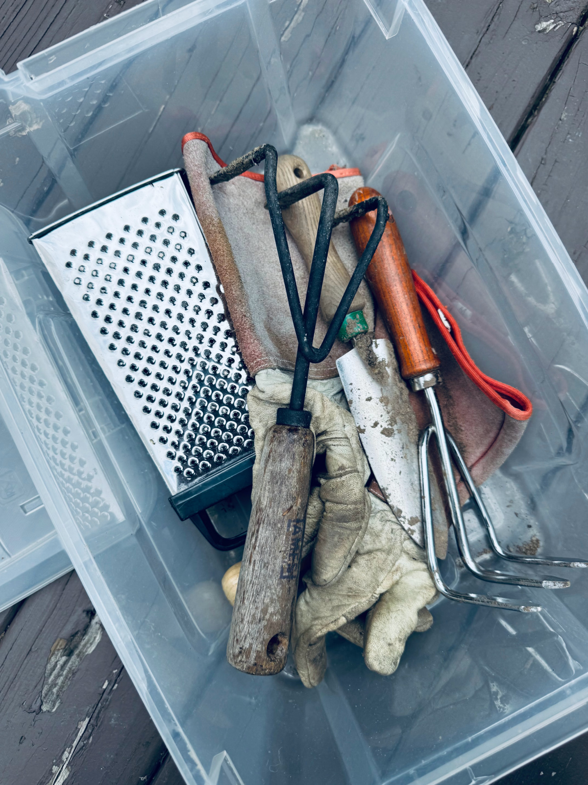 gardening tools in clear bin.