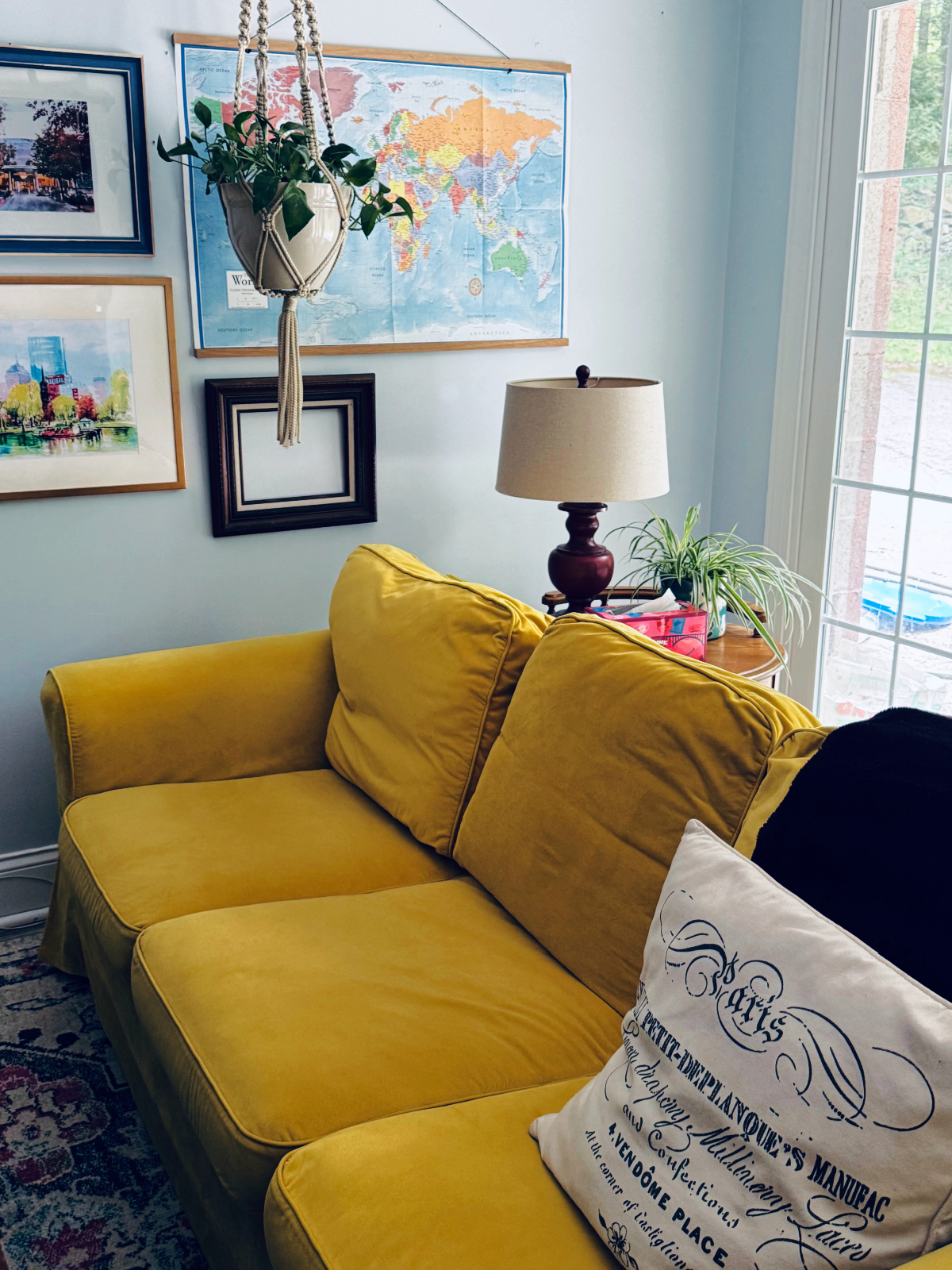 clutter free living room with art and yellow couch.