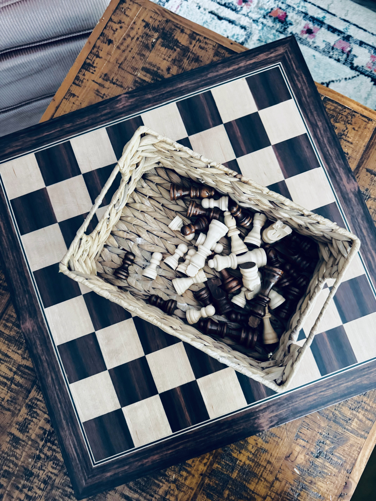 chess board with basket on chess pieces on coffee table.