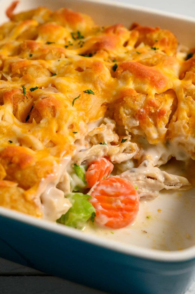 chicken tater tot casserole in white casserole dish.