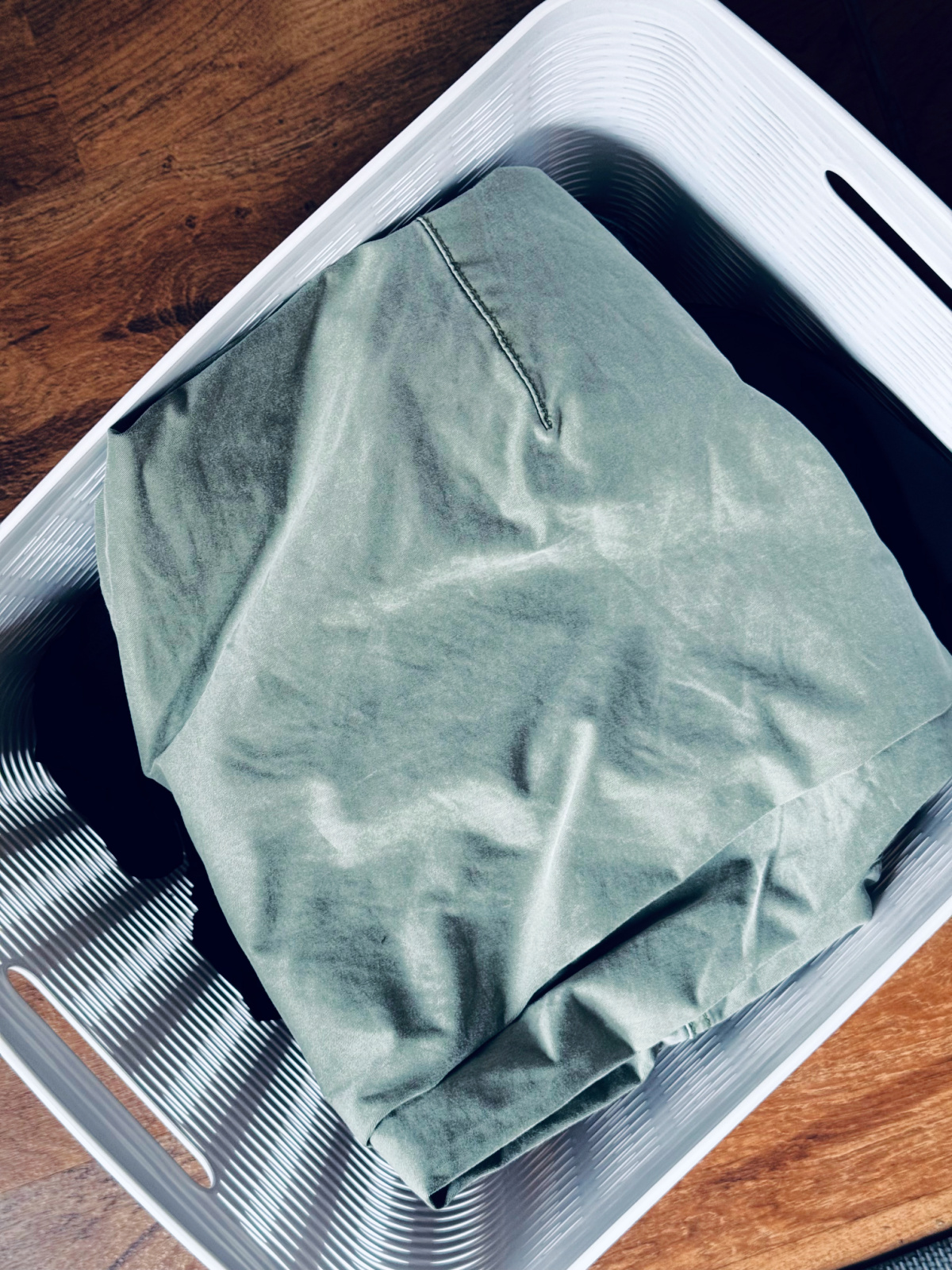 white plastic bin full of clothing to be decluttered.