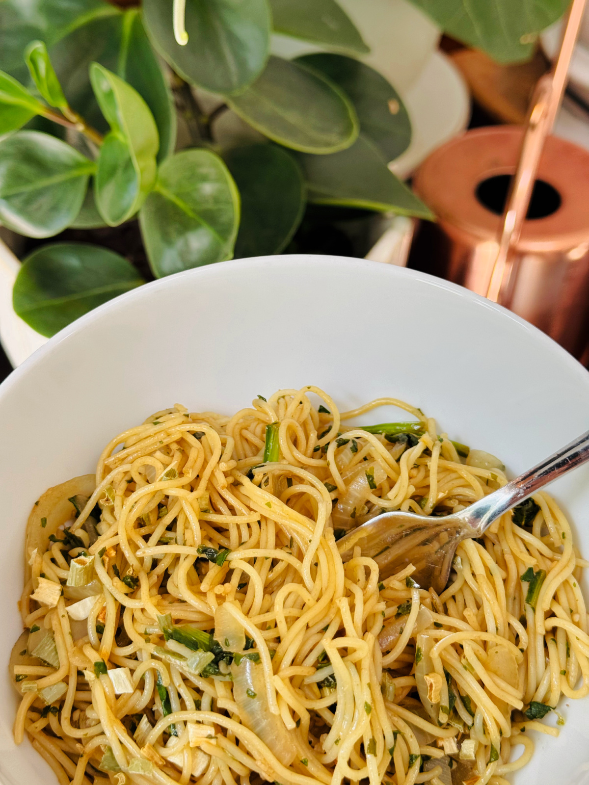 serving of veggie lo mein in white bowl with dried scallions on top.