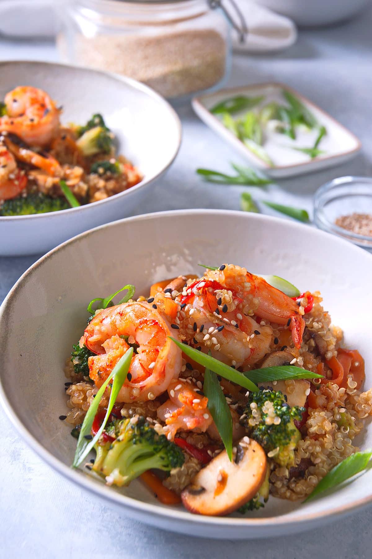 quinoa shrimp and veggie stir fry in white bowl, close up.