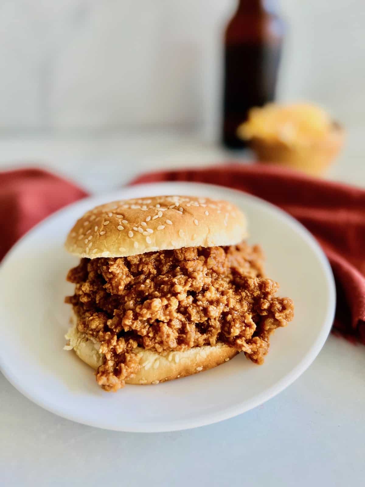 three ingredient sloppy joes on a sesame seed bun on white plate.