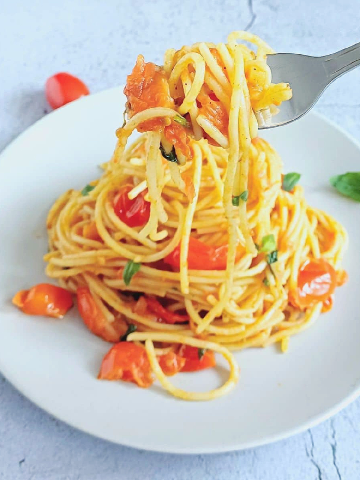 serving of 15 minute tomato basil pasta on white plate.
