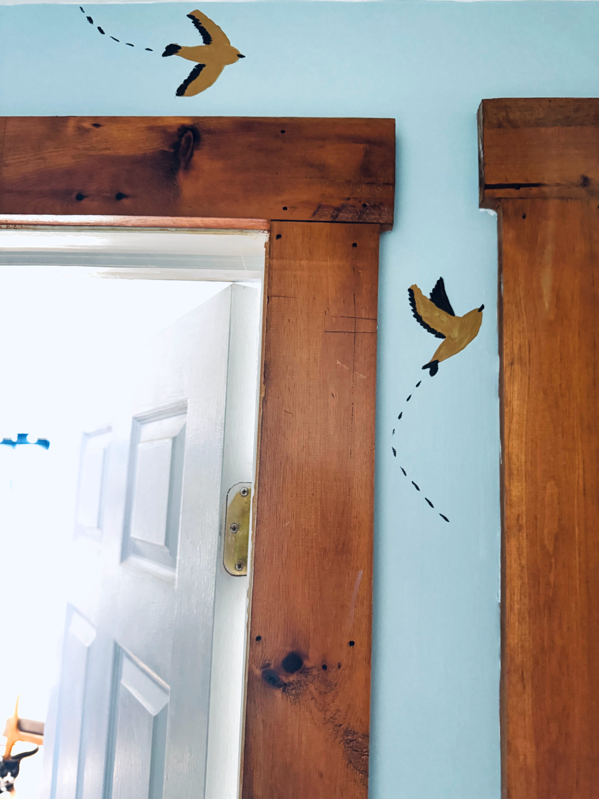 close up of diy sparrow wallpaper near doorframe.