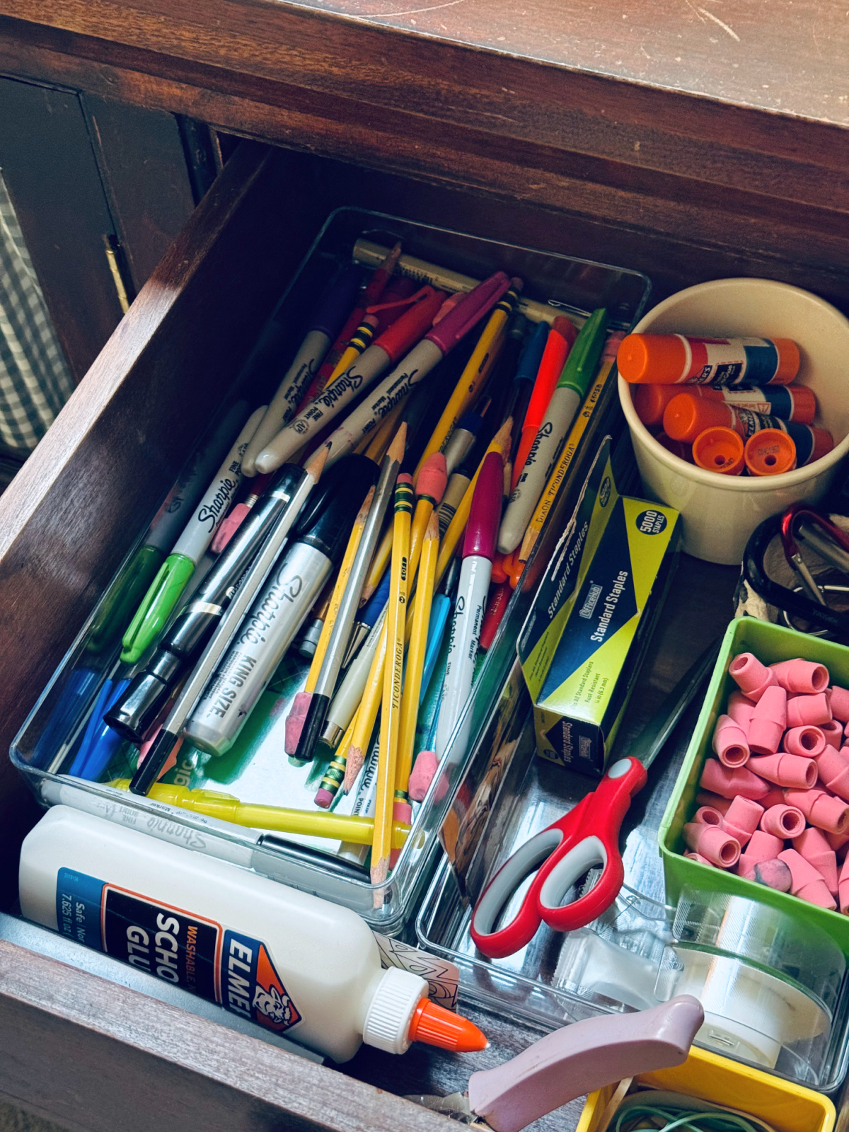 office supply drawer with pencils, scissors, tape and more.